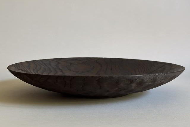 Dark wooden bowl on a light gray background