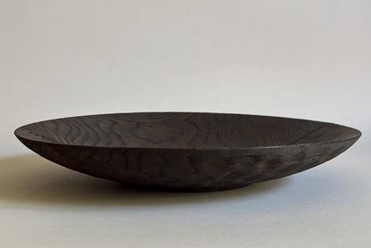 Dark wooden bowl on a light gray background