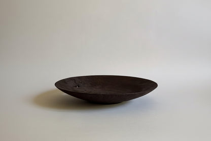 Dark wooden bowl on a light gray background