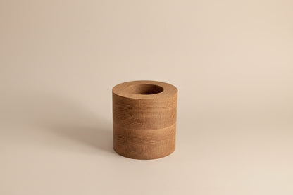Wooden cylindrical object on a light gray background
