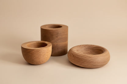 Three wooden bowls of different shapes and sizes on a light background